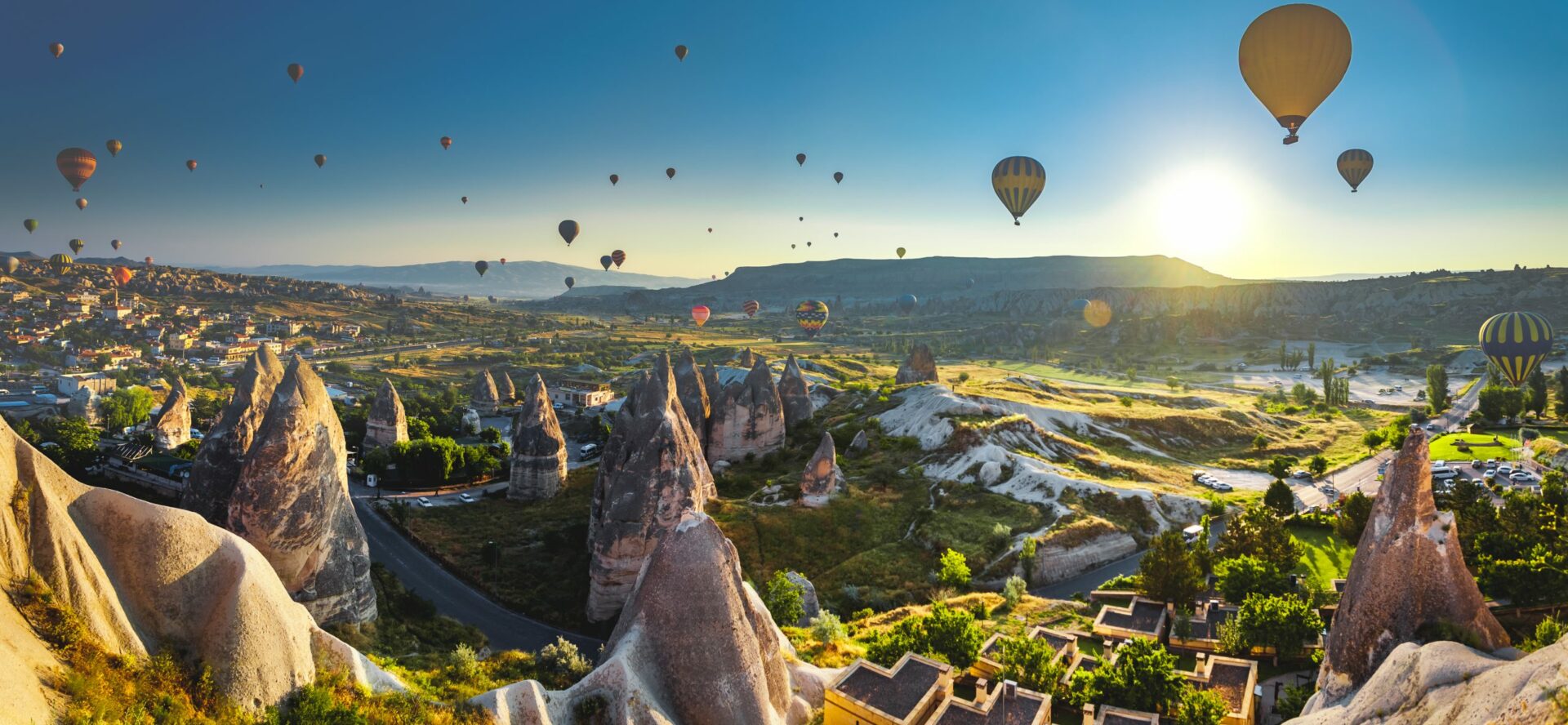 Spektakuläre Heißluftballonfahrt über eine atemberaubende Landschaft, während die aufgehende Sonne den Himmel in warme Farben taucht. Ein unvergessliches Abenteuer und ein absolutes Bucket-List-Erlebnis für alle, die Freiheit, Luxusreisen und außergewöhnliche Momente in luftiger Höhe genießen möchten.