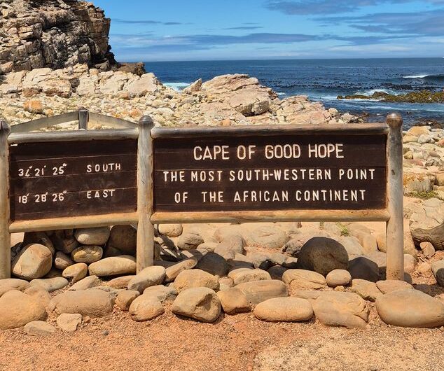 Das Bild mit dem Schild „Cape of Good Hope – The Most South-Western Point of the African Continent“ zeigt den berühmten Kap-der-Guten-Hoffnung-Nationalpark.