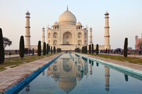 Das majestätische Taj Mahal in Indien, ein Symbol ewiger Liebe und ein Meisterwerk der Architektur, spiegelt sich perfekt im Wasserbecken des prächtigen Gartens. Dieses UNESCO-Weltkulturerbe bietet eine exklusive Kulisse für unvergessliche Luxusreisen und kulturelle Entdeckungen. Perfekt für Reisende, die die Magie und Pracht Indiens hautnah erleben möchten.