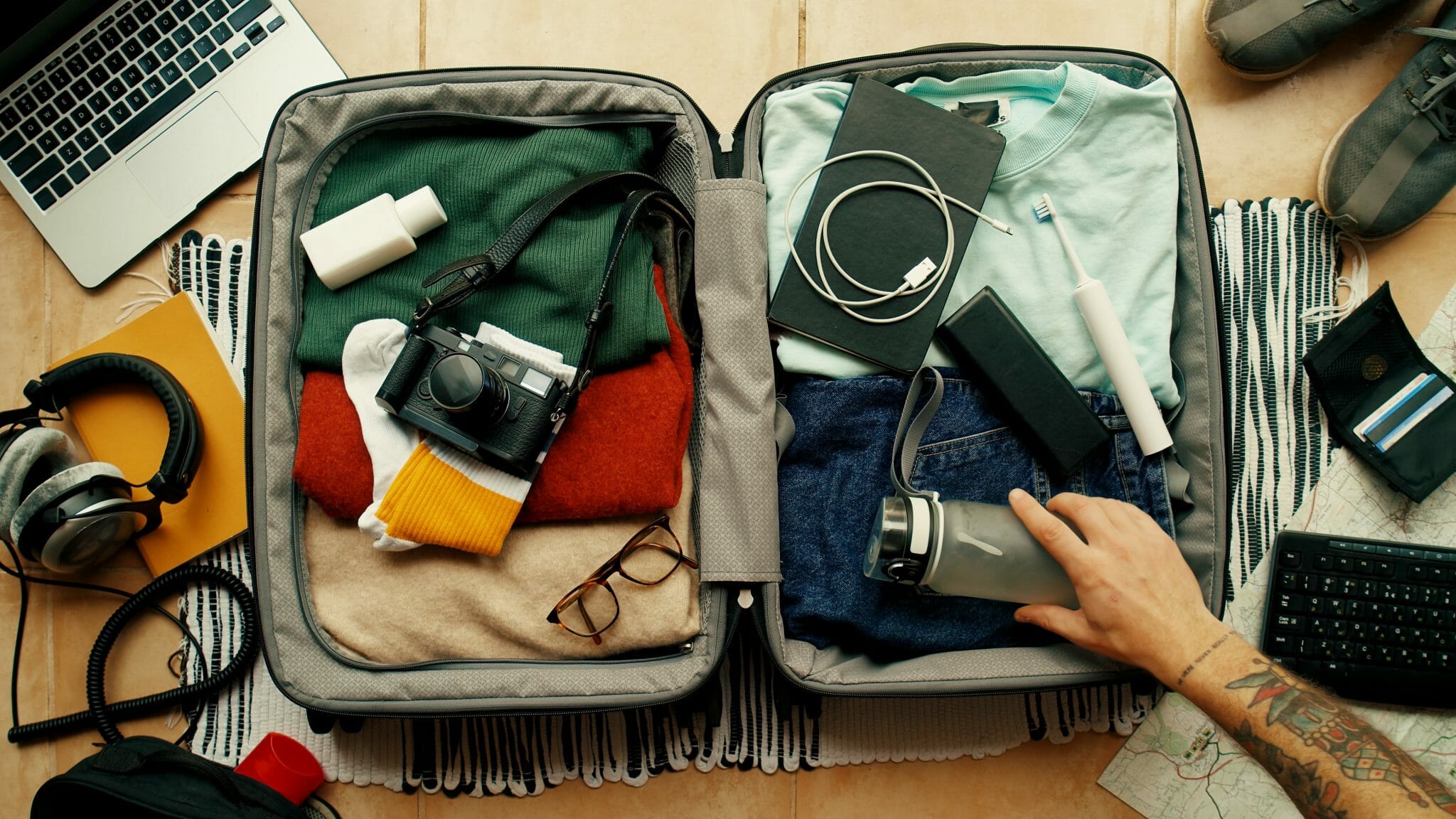 : "Perfekt gepackter Koffer mit Kleidung, Accessoires und Reisedokumenten – alles nach den richtigen Regeln für effizientes und stressfreies Packen sortiert. Eine ideale Vorbereitung für jede Reise, ob Kurztrip oder Langstrecke, mit smarten Tipps für platzsparendes Packen und die wichtigsten Reise-Essentials.