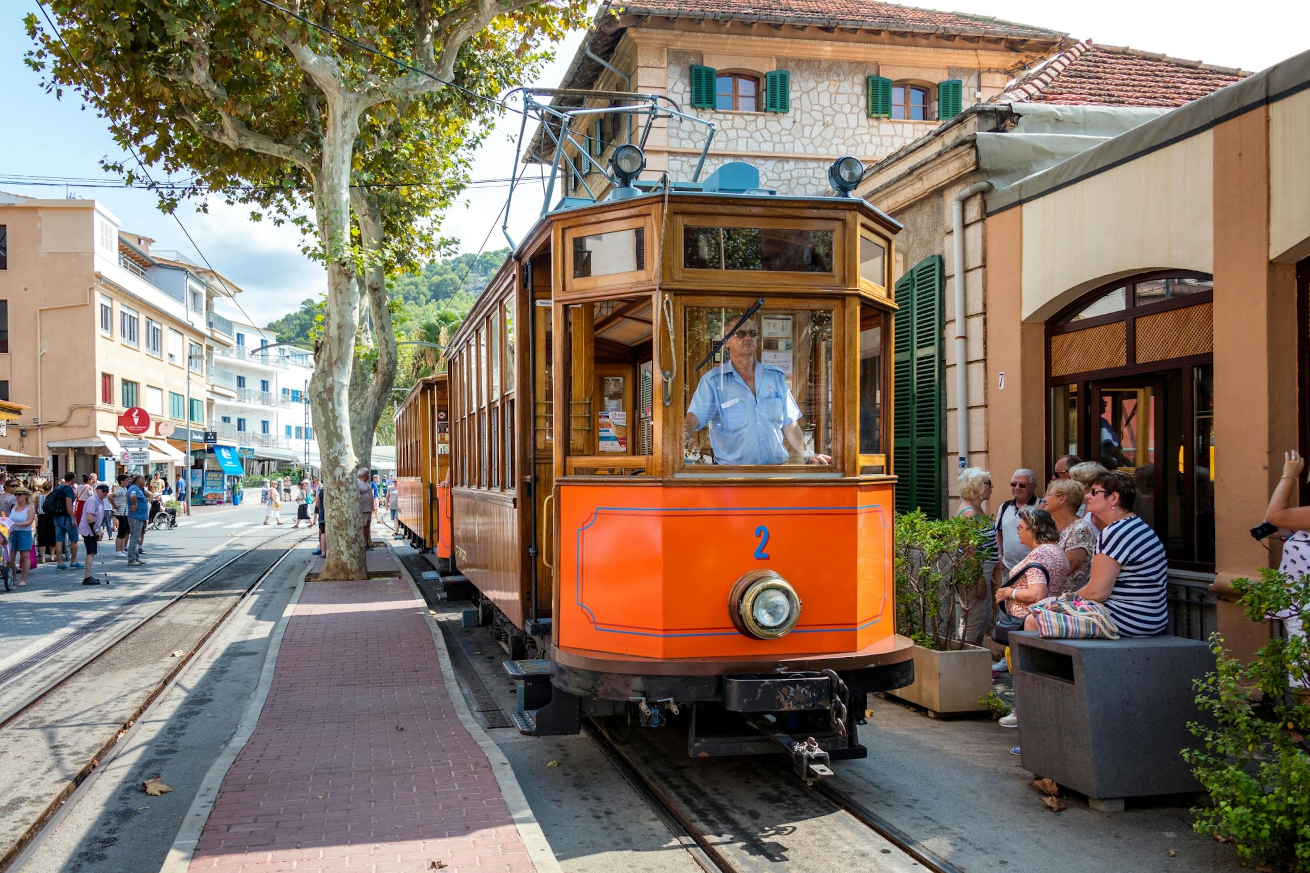 Die nostalgische Straßenbahn von Sóller auf Mallorca fährt durch die charmante Altstadt und versprüht einzigartiges mediterranes Flair. Mit ihren eleganten Holzverkleidungen und der ikonischen orangefarbenen Lackierung bietet sie eine exklusive Zeitreise in die Vergangenheit. Perfekt für Reisende, die Luxus, Tradition und die Schönheit Mallorcas stilvoll erleben möchten