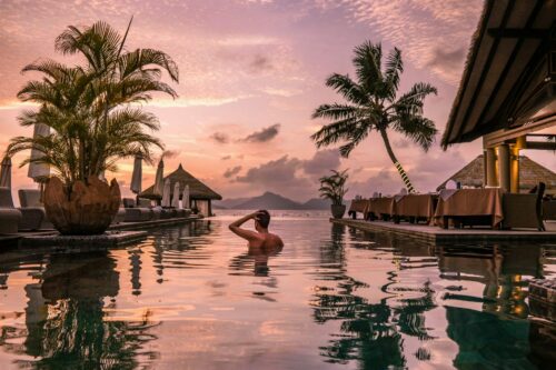 Luxuriöser Infinity-Pool mit Blick auf das türkisfarbene Meer der Seychellen, umgeben von tropischer Natur. Ein exklusiver Traumurlaub für Genießer, die Ruhe, Erholung und erstklassigen Komfort in einer paradiesischen Umgebung suchen.