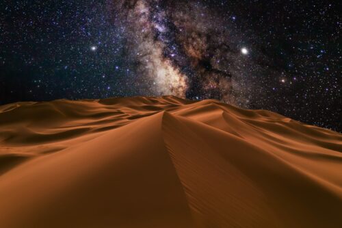 Magische Nächte in der Wüste unter einem atemberaubenden Sternenhimmel. Millionen von funkelnden Sternen leuchten über der sandigen Landschaft und schaffen eine unvergleichliche Kulisse für Stargazing und unvergessliche Naturerlebnisse. Perfekt für Abenteuerreisende, die die Stille, Weite und Schönheit der Wüste bei Nacht erleben möchten.